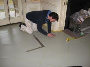 The wide plank flooring was first prepared and painted. We then began to layout the floor in a diagonal pattern.